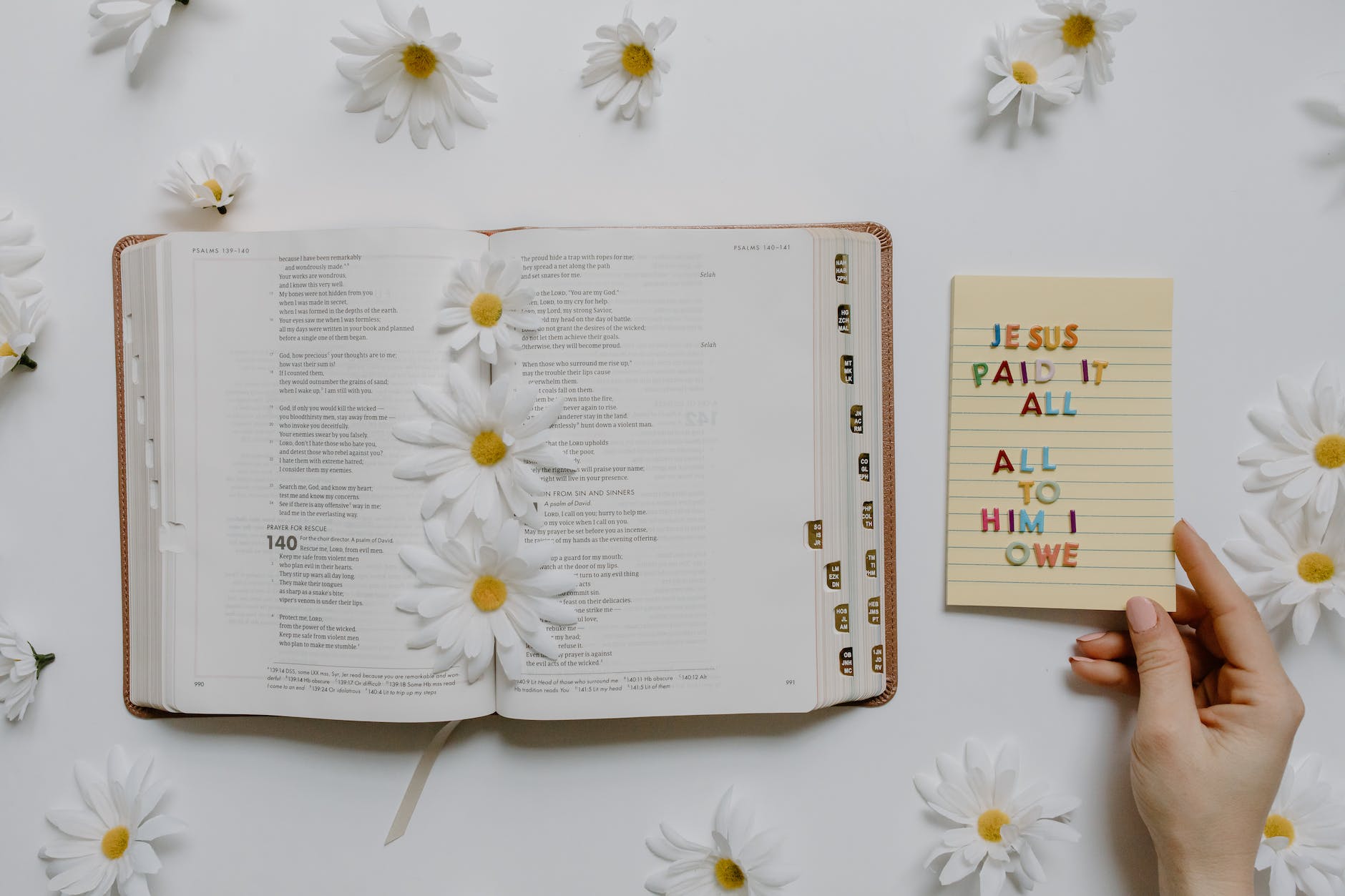 an open bible with flowers and a notepad