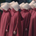 Bureaucratic eugenics. group of women in long red cloaks and white head coverings in formation representing dystopian america.
